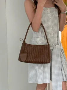 Brown woven shoulder bag for women, chic leather baguette handbag, elegant daily commuting purse.