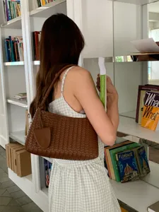 Woven shoulder bag for women, stylish brown leather baguette bag, chic daily commute handbag.