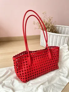 Red woven cutout tote bag for women, stylish hollow shoulder bag with double braided handles.