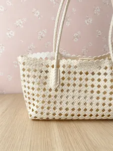 Woven hollow shoulder tote bag detail, featuring durable handle and elegant lace trim design.