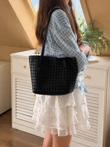 Vue détaillée du sac cabas épaule tressé en cuir noir pour femme au quotidien.