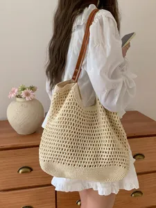 Detail view of the beige hand-woven shoulder tote bag, showcasing hollow-out texture and straps.