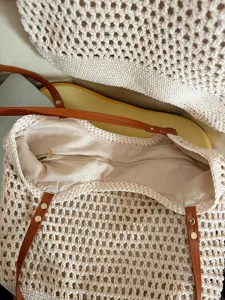 Detailed view of the handmade crochet tote bag showing interior lining, zipper pocket and straps.