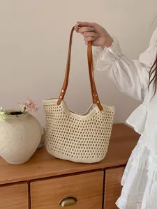 Hand-woven beige crochet tote bag with brown leather straps for beach trip and daily use.