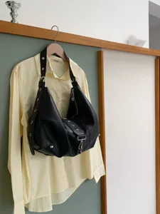 Black soft leather hobo bag detail featuring metal buckles and casual commuter style design.