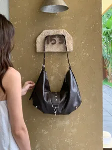 Detailed view of the dark brown slouchy soft leather shoulder bag with star rivets and casual style.