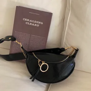 Trendy black crescent waist bag with chain detail, versatile sling and shoulder bag for women.