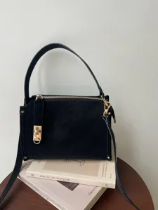 Elegante schwarze Retro-Box-Umhängetasche mit schickem Goldbeschlag für den täglichen Weg zur Arbeit.