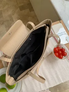 Detailed view of beige woven tote bag interior with pockets, casual straw design.