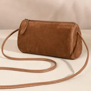 Brown suede barrel bag detail showcasing soft texture, premium zipper, and strap.