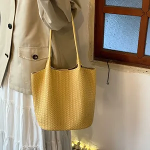 Stylish yellow woven tote bag with a chic shoulder strap design for daily commuter use.