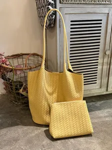 Yellow woven leather tote bag and pouch detail view showing intricate texture and design.