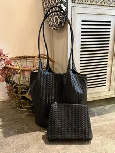 Woven tote bag for women, large capacity shoulder commuting bag with matching pouch detail.