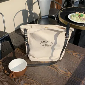 Borsa a tracolla casual in tela con cinturino in pelle a contrasto per uso quotidiano.
