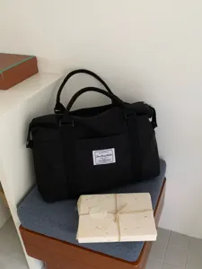 Dettaglio borsa da viaggio in tela nera, grande borsa weekend per brevi viaggi.