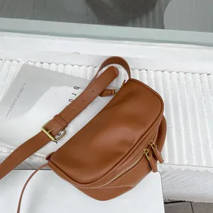Brown soft leather crossbody bag for women with wide strap, trendy chic design style.