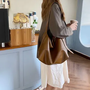 Detailed view of the brown slouchy minimalist shoulder bag showcasing its soft leather texture.