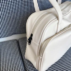 Detail view of the cream white large capacity travel tote bag, featuring a double zipper.
