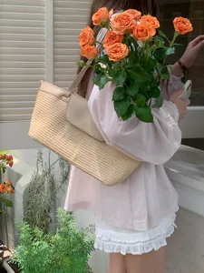 Detail shot of a vintage French woven straw shoulder bag paired with orange roses in daily use.