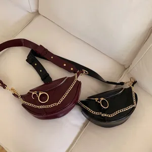 Detail shot of stylish crescent waist bag with chunky gold chain and ring zipper pulls.