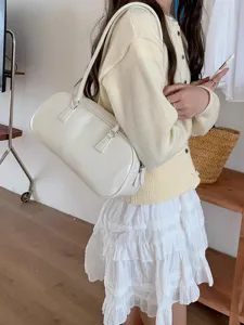 Chic minimalist white shoulder bag, elegant elongated design for daily wear outfits.
