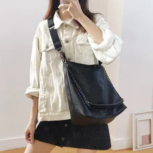 Detailed shot of a stylish black bucket bag with chain and wide strap, casual everyday fashion wear.