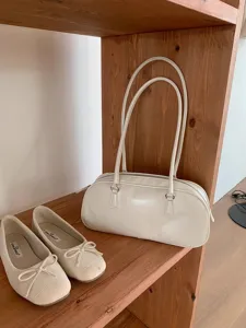 Minimalist white patent leather shoulder bag with double straps, stylish and elegant everyday accessory.