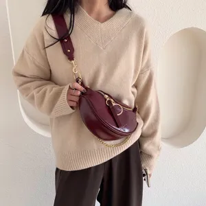 Women fashion burgundy chest bag stylish shoulder crossbody bag with trendy chain detail.