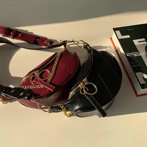 Stylish crescent waist bag for women, versatile crossbody design with metallic chain and ring zipper.