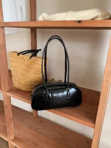 Black underarm shoulder bag detail shot, minimalist design, elegant daily accessory.