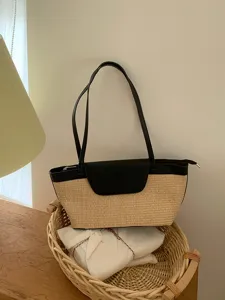 Detail view of a French vintage straw shoulder bag with black PU leather flap and straps.