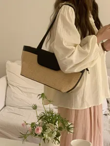 Detail shot of French vintage straw woven shoulder bag, elegant summer beach tote style.