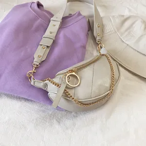 Trendy sling bag with wide strap and gold chain accent, stylish women chest bag.