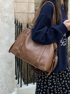 Brown PU leather travel tote bag detail showing large capacity and sturdy handles.