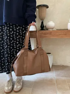 Close-up detail of the stylish brown PU leather travel duffel bag with large capacity.