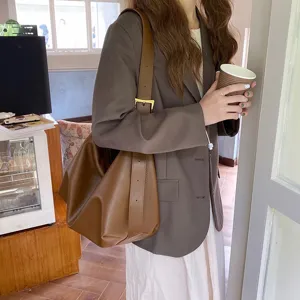 Vista dettagliata della borsa a spalla marrone morbida e minimalista in stile hobo.