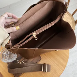 Brown leather tote bag interior detail view showcasing large capacity and zippered compartments.