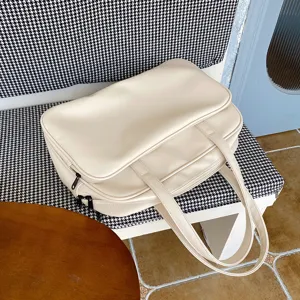 Detailed view of the large capacity beige travel tote bag showing smooth leather texture and double handles.