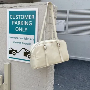 Minimalist cream shoulder bag for women, chic underarm purse with dual straps and sleek zip design.