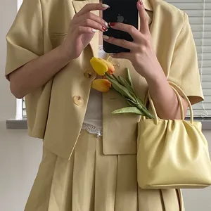 Light yellow square pleated crossbody bag, detailed shot showcasing soft texture and trendy style.