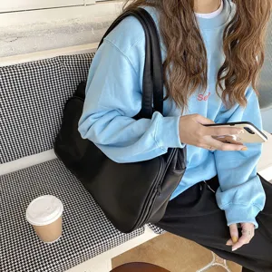 Detail view of large black leather shoulder bag, casual travel tote and fashion commuter bag.