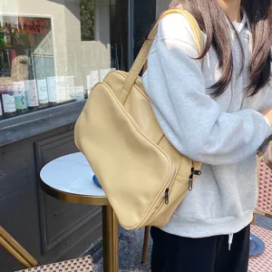 Detail shot of the large capacity yellow leather shoulder tote bag worn by model outdoors.