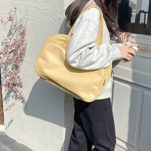 Large capacity yellow shoulder bag for women, stylish tote bag for travel and commute.