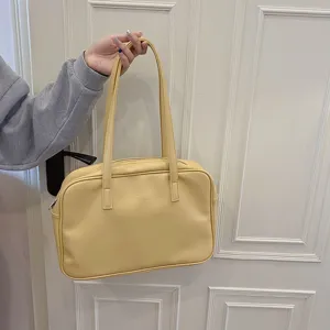 Yellow leather shoulder bag for women, classic tote handbag with double handles and zip.
