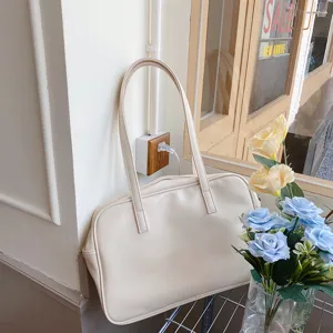 Detail view of a minimalist cream tote bag with dual straps, elegant and spacious design.