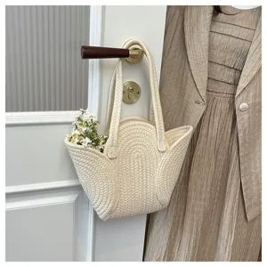 Detailaufnahme der handgefertigten geflochtenen Umhängetasche mit Blütenform und Blumendekor.