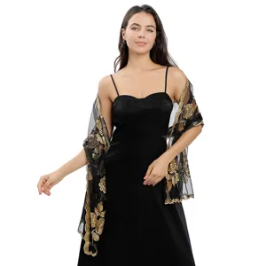 Détail en gros plan d'un châle en résille noire brodé de sequins avec bordure florale.