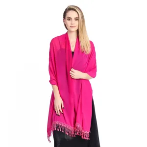 Detailed shot of a vibrant hot pink chiffon shawl with delicate lace fringe worn by a model.