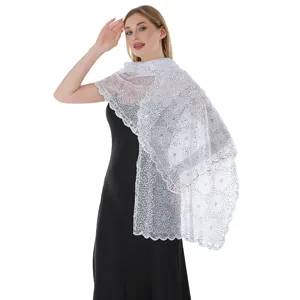 White sequin lace shawl detail, elegant floral embroidery craftsmanship close-up view.
