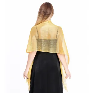 Detail view of the shimmering gold metallic evening shawl, showing delicate fringe texture.